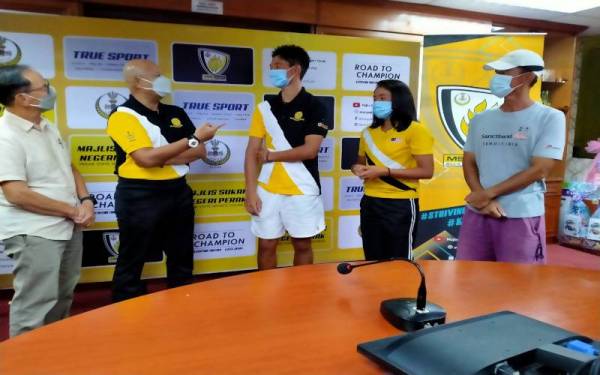 Fazwil (dua dari kiri) menyampaikan cek sumbangan Persatuan Lawn Tenis Perak kepada Mitsuki dan Shihomi di Bilik Mesyuarat Majlis Sukan Negeri Perak di sini pada Sabtu.