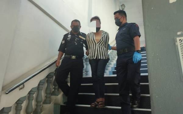 Polis mengiringi seorang lelaki yang berperwatakan wanita yang didakwa di Mahkamah Majistret pada Ahad atas pertuduhan melindungi seorang Long Tiger.