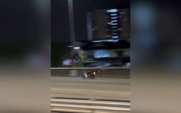 Seorang penunggang motosikal melakukan aksi berbahaya.