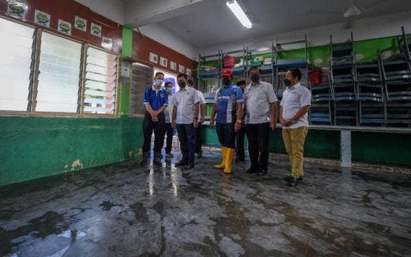 Mohamad Alamin (dua. kiri) meninjau proses pembersihan di Sekolah Kebangsaan Pogoh yang terjejas akibat banjir hari ini. -Foto Bernama