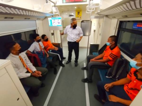 Mohd Zain (berdiri) menaiki tren dari hentian Kuala Gris ke Stesen Dabong, Kuala Krai bersama-sama pelajar dan meluangkan masa bersama mereka pada Isnin.