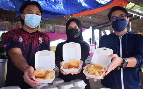 Sukarelawan Yayasan UMP menunjukkan roti canai yang disediakan untuk diedarkan kepada mahasiswa UMP secara percuma pada Sabtu lalu.