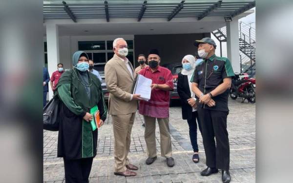Najib menerima Memorandum Tuntutan Pengeluaran Kali Terakhir KWSP Akaun 1 sebanyak RM10,000 secara one-off daripada wakil Suara Pencarum Seluruh Malaysia, Azmi Mohd Tahir diiringi Ketua Aktivis Persatuan Islam Malaysia (PPIM), Datuk Nadzim Johan (kanan) di Jalan Bukit Pantai, Bangsar, Kuala Lumpur pada Selasa. - Foto FB Najib