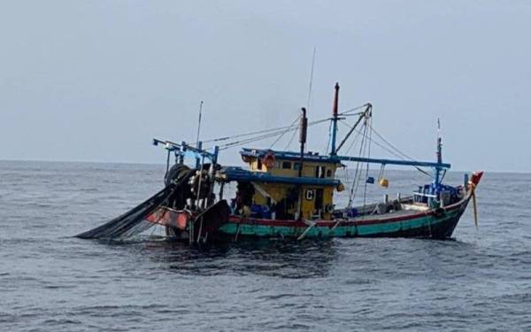 Sebuah bot nelayan dikendalikan tiga warga asing ditahan kerana melakukan kesalahan di bawah Akta Perikanan 1985. - Foto Ihsan Maritim Malaysia.