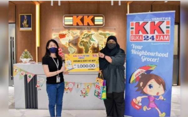 Ketua Pemasaran KK Super Mart, Linly Chong (kiri) menyerahkan replika cek kepada pemenang peraduan KK-reate My Bag, Noranita (kanan) baru-baru ini.