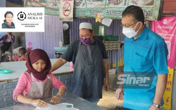Azlan (kanan) melihat Yusna Asna menebar roti canai di gerai makanan keluarganya berhampiran persimpangan lampu isyarat Balai Baru, Padang Besar pada Ahad. Turut kelihatan Ruslin (kanan).