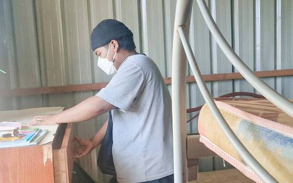 Muhammad Syazmi Aiman mengemas barang-barang untuk berpindah ke rumah baharu di Pangsapuri Pokok Mangga.