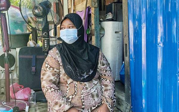 Syurnida Juliati duduk di tangga pondok usang yang didiami bersama dua anaknya di Kampung Bukit Rambai, Melaka pada Khamis.