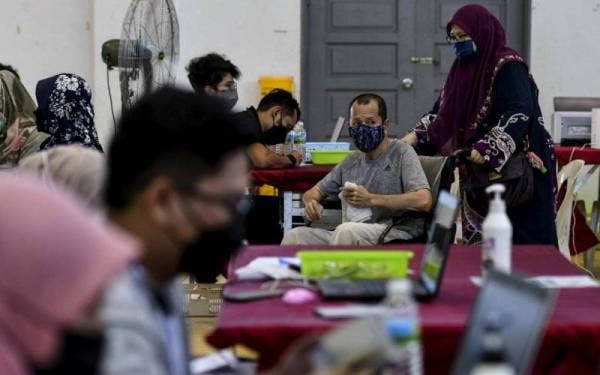 Penerima vaksin hadir bagi mendapatkan suntikan dos ketiga atau dos penggalak vaksin Covid-19 di Pusat Pemberian Vaksin (PPV) Covid-19 di Dewan Projek Perumahan Rakyat (PPR) Padang Hiliran.- Foto Bernama