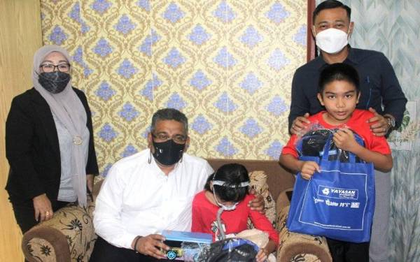 Megat Zulkarnain (duduk) menyerahkan sumbangan mesin bantuan pernafasan kepada Ainul Nuraishah di kediamannya di Bandar Mahkota Cheras, Cheras, pada Khamis.