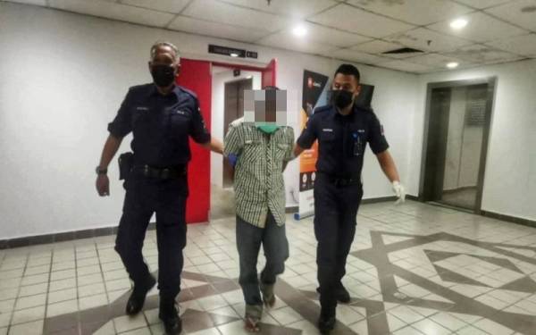 Tertuduh (tengah) dihadapkan ke Mahkamah Sesyen di Kuala Terengganu pada Khamis.