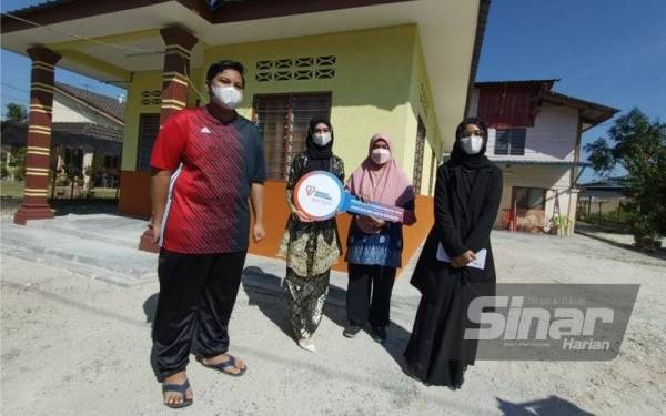 Norismah (dua dari kanan) bersama tiga anaknya di hadapan rumah baharu mereka di Kampung Tersusun Sungai Terap, Batu Gajah.