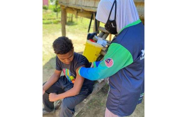 Anggota PBOA PKD Cameron Highlands memberikan vaksin booster dosis kepada warga Kampung Bah Renjis melalui bakti sosial pada Selasa.  - Foto FB JKNP