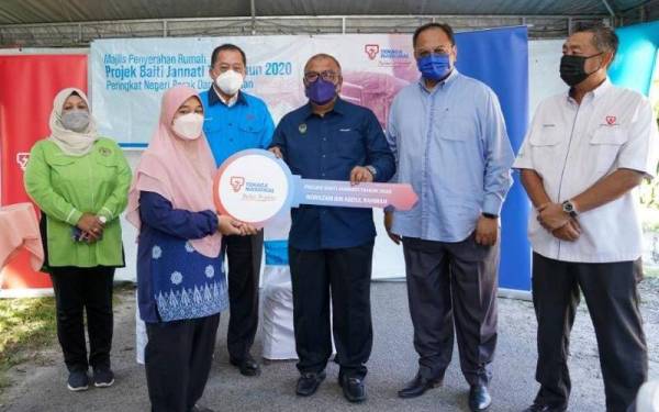 Pengerusi Jawatankuasa Infrastruktur, Tenaga, Air dan Pengangkutan Awam Negeri Perak, Datuk Zolkafly Harun (tiga dari kanan) diiringi Baharin Din (tiga dari kiri) menyampaikan replika kunci kepada Norismah di Majlis Kesyukuran PBJ TNB di Kampung Tersusun Sungai Terap, Batu Gajah, Perak pada Jumaat.