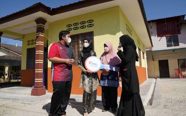 Norismah (dua dari kanan) bersama anak-anaknya kelihatan gembira di hadapan rumah baharu mereka selepas menerima kunci rumah sumbangan dari Projek Baiti Jannati TNB pada Jumaat.