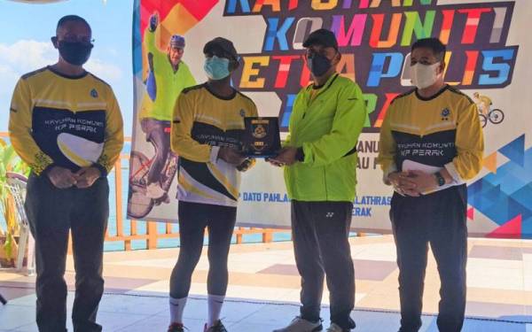 Zambry (dua dari kiri) menerima cenderahati daripada Mior Faridalathrash (dua dari kanan) pada program High Profile Policing (HPP) dan kayuhan komuniti Ketua Polis Perak di Pulau Pangkor pada Sabtu.