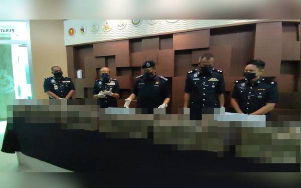 Ketua Polis Kedah, Komisioner Wan Hassan Wan Ahmad (tengah) meneliti dadah jenis ganja yang dirampas pada sidang akhbar di Ibu Pejabat Polis Kontijen (IPK) Kedah, di sini, pada Ahad.