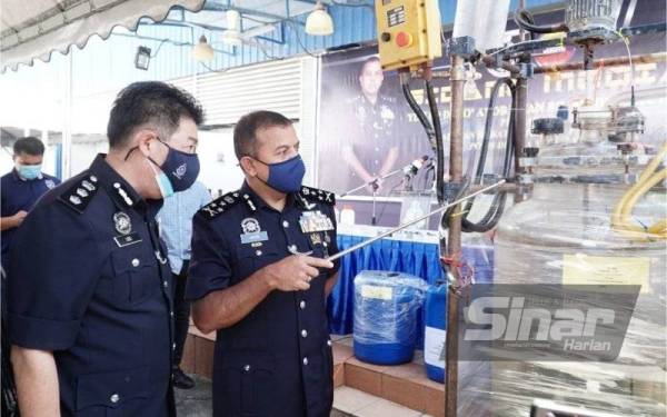Ayob Khan (dua dari kiri) diiringi Ketua JSJN Perak, Asisten Komisioner Lee King Chuan melihat peralatan yang digunakan untuk memproses dadah.