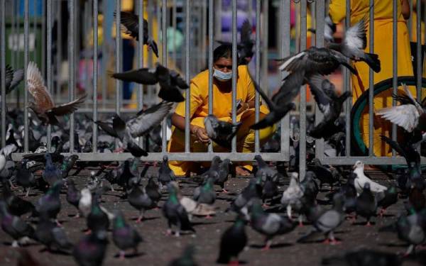 Orang ramai khususnya penganut Hindu mematuhi SOP seperti pemakaian pelitup separuh muka, pemeriksaan suhu badan dan mendaftar masuk menggunakan aplikasi MySejahtera yang ditetapkan oleh Kementerian Kesihatan ketika hadir bagi upacara keagamaan menjelang Thaipusam di Kuil Sri Subramaniar Swamy, Batu Caves pada Ahad. - Foto Bernama