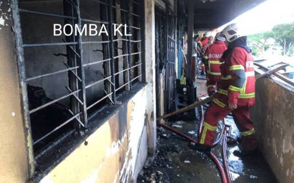 Anggota bomba memadamkan kebakaran di dua buah rumah di Rumah Pangsa DBKL