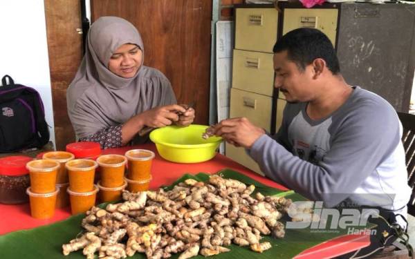 Pasangan orang kurang upaya (OKU) fizikal, Muhammad Hafidz Abdul Rahman, 40, (kanan) dan isteri, Nurul Izzaifah Daud, 33, bersama-sama mengupas kulit kunyit sebelum dikisar dan digaul bersama garam sebelum dijual kepada pelanggan.