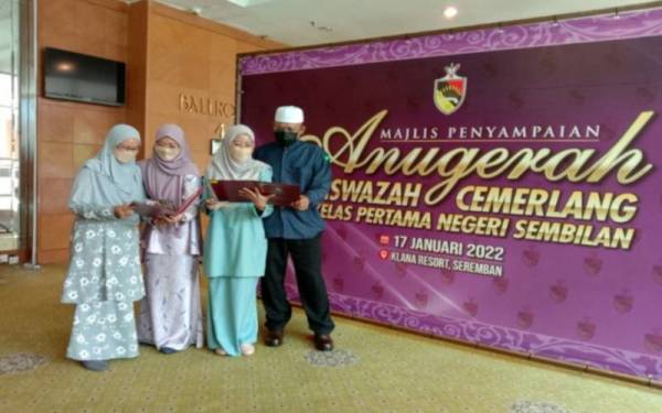 Rosli (kanan) dan Zarina (kiri) bersama dua anak mereka yang menerima anugerah kecemerlangan di Seremban pada Isnin.
