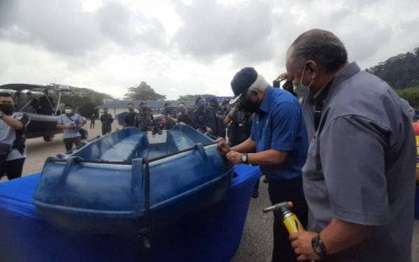 Hamzah, (dua kiri) menguji ketahanan bot pada sesi lawatan kerja Pengurusan Banjir Pantai Timur di Kem Pasukan Gerakan Am (PGA) Galing di sini pada Isnin.