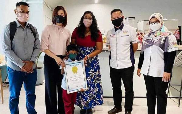 Sugendran (kiri) bersama Kashrav (depan) dan Sharlini (tiga dari kanan) menunjukkan sijil pengiktirafan Malaysia Book of Records.