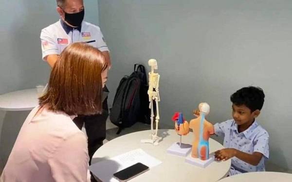 Kashrav (kanan) menerangkan fisiologi sistem badan manusia kepada penilai yang merupakan pakar bidang tersebut untuk membuat penilaian kelayakan anugerah Malaysia Book of Records baru-baru ini.