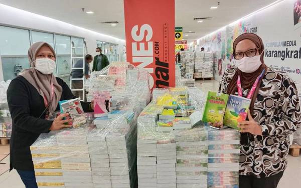 Roziana (kiri) bersama Ketua Pegawai Eksekutif Grup Buku Karangkraf, Firdaus Hussamuddin menunjukkan antara novel yang dijual menerusi jualan penghabisan stok sempena Jualan Gudang Karangkraf 2022 yang bermula hari ini.