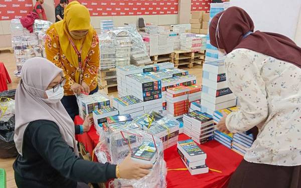 Karyawan Grup Buku Karangkraf menyusun bahan bacaan sebagai persiapan akhir Jualan Gudang Karangkraf 2022 pada petang Khamis.