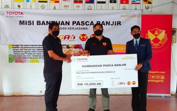 Tengku Amir Shah (tengah) diiringi Ravindran (kiri) berkenan menyampaikan sumbangan kepada Azril yang mewakili SK Sungai Lui di Hulu Langat pada Rabu.