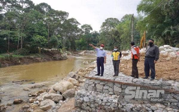 Izham (kiri) meninjau kerja-kerja pembaikan cerun dan tanah runtuh di Genting Peras, Hulu Langat dan kawasan sekitarnya pada Jumaat. - Foto Sinar Harian