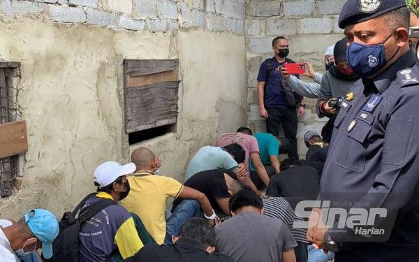 Kamarul Zaman (kanan) memeriksa antara individu yang ditahan atas kesalahan penyalahgunaan dadah di Kampung Pandan, pada Jumaat