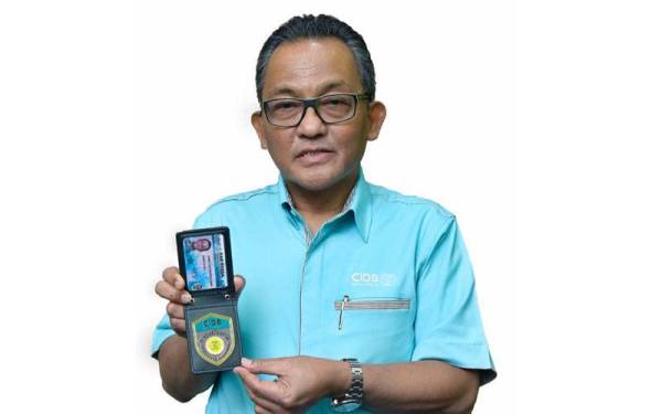 Ahmad ‘Asri menunjukkan lencana anggota penguat kuasa CIDB.