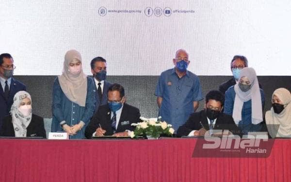 Menteri Pembangunan Luar Bandar, Datuk Seri Mahdzir Khalid (tengah), melihat proses menandatangani memorandum antara Lembaga Kemajuan Wilayah Pulau Pinang dan Perodua Sales Sdn. Bhd disaksikan oleh Presiden/Ketua Pegawai Eksekutif Perusahaan Otomobil Kedua Sdn. Bhd (Perodua), Datuk Zainal Abidin Ahmad dan Pengerusi Lembaga Kemajuan Wilayah Pulau Pinang, Khaliq Mehtab Mohd Ishaq pada majlis Menandatangani Memorandum Persefahaman (Diperbaharui) antara Lembaga Kemajuan Wilayah Pulau Pinang dan Perodua Sales Sdn. Bhd. - Foto Sinar Harian ROSLI TALIB