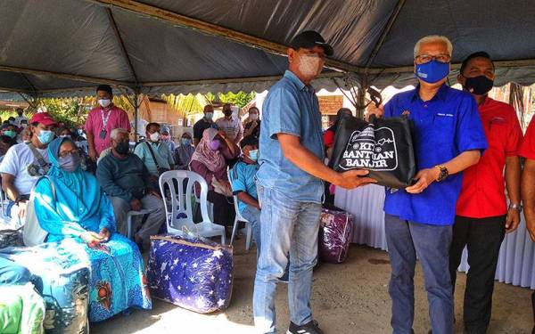 Ismail Sabri (depan kanan) menyampaikan sumbangan kepada mangsa banjir di pekarangan Masjid Kampung Guai di Bera pada Ahad.