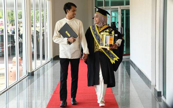 Noor Syafiqah Azim bersama suami selepas menerima Anugerah Pelajaran DiRaja (Pingat Jaya Cemerlang) pada Majlis Idul Ilmi Konvokesyen Universiti Sultan Zainal Abidin (UniSZA) kali ke-12 pada Ahad.