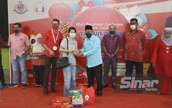 Tosrin (tengah) menyampaikan sumbangan Tahun Baharu Cina daripada Yayasan Sejahtera MPKu di Dewan Raya Putra Bandar Putra Kulai pada Isnin.