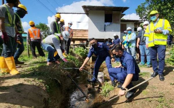 Penguat kuasa JANS memotong sambungan haram untuk mencuri bekalan air menerusi saluran paip utama di penempatan setinggan Tebobon, Manggatal, Kota Kinabalu.