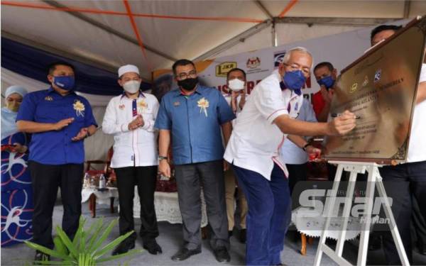 Mahdzir (kanan) menandatangani plak sempena Majlis Perasmian Jambatan Pemberian, Kuala Krai, pada Isnin.