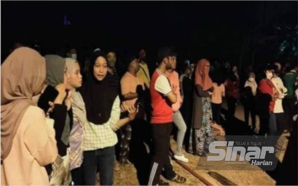 Mangsa dan orang ramai melihat anggota bomba memadamkan kebakaran.