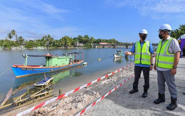 Fadilah (kiri) dan Ahmad Samsuri melihat lokasi tapak projek naik taraf Jambatan Marang di Marang ketika merasmikan majlis pecah tanah projek naik taraf Jambatan Marang di sini pada Selasa.