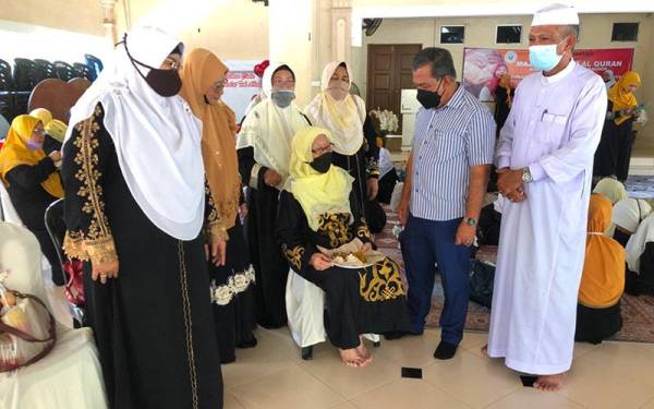 Mohd Zain (dua dari kanan) dan Zakiah (kanan) beramah mesra dengan peserta Majlis Khatam al-Quran Wanita UMNO Bahagian Bachok di Chalet Pantai Tok Abah, Bachok, pada Selasa.