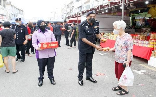 Ketua Polis Daerah Klang Utara, Asisten Komisioner S Vijaya Rao(tengah) menyampaikan sumbangan limau kepada masyarakat ketika Program Walk About di Taman Eng Ann di sini pada Rabu.