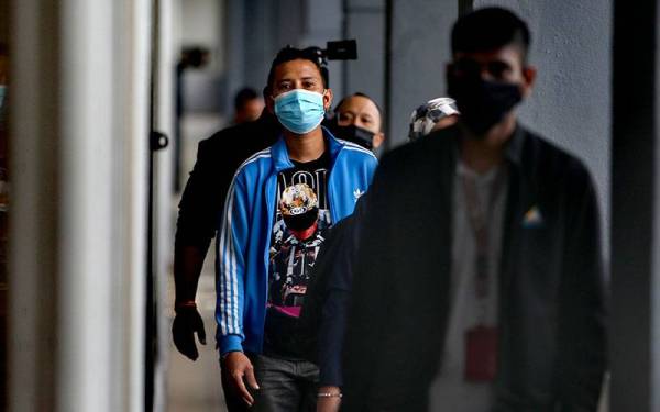 Muhammad Faiz memakai baju berwarna biru ketika hadir ke mahkamah pada Rabu.