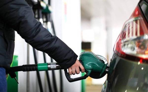 Gambar fail menunjukkan seorang pengguna mengisi petrol di sebuah stesen minyak di London. - Foto AFP