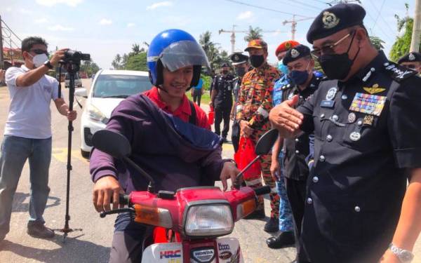 Shafien (kanan) diriingi Shuhaimi (dua dari kanan) ketika Majlis Pelancaran Op Selamat 17/2022 Sempena Perayaan Tahun Baharu Cina di Tunjong, Kota Bharu pada Khamis. - Foto Sinar Harian