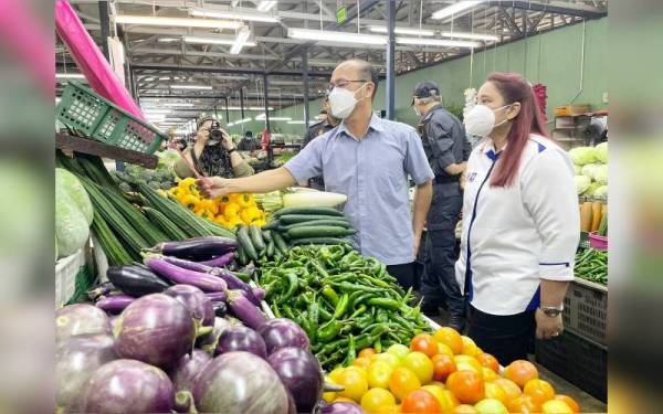 Norena (kanan) dan Hee Sem (kiri) ketika membuat tinjauan harga barangan keperluan menjelang Tahun Baharu Cina di Pasar Awam Melaka, di Bachang, pada Khamis.