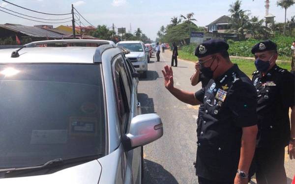 Ketua Polis Kelantan, Datuk Shafien Mamat (dua, kanan) melambai kepada pengguna jalan raya sempada perasmian Majlis Pelancaran Op Selamat 17/2022 Sempena Perayaan Tahun Baru Cina.